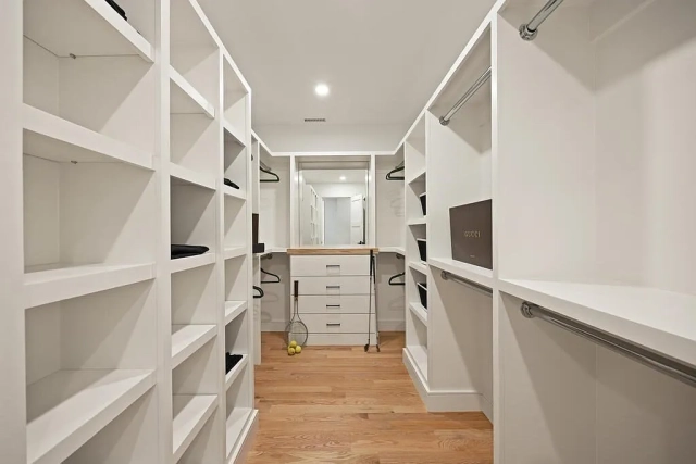 In the picture, a white custom closet with drawer and shoe rack