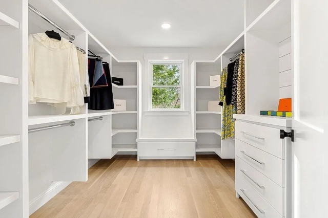 In the picture, a white custom closet with drawer and shoe rack